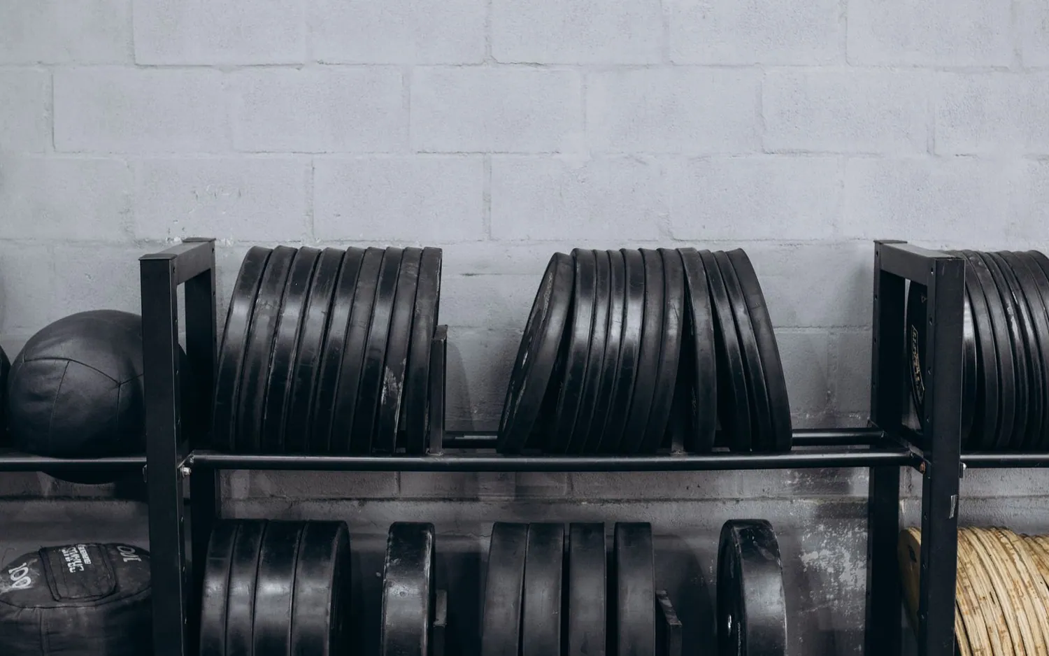 Rack de disques et medicine balls dans une salle de sport classique pour l'entraînement Hyrox